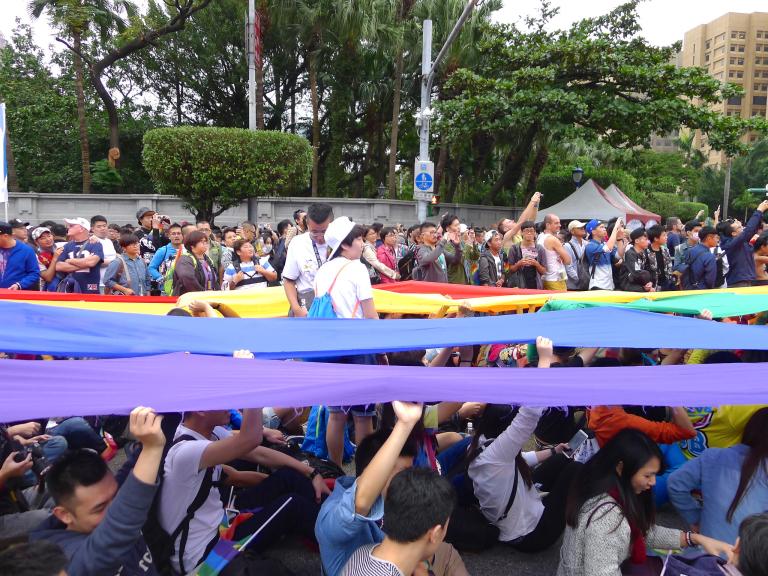Protest with rainbow flags above head